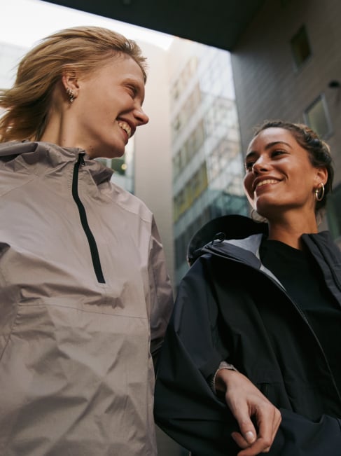 Two women smiling as they walk through the city