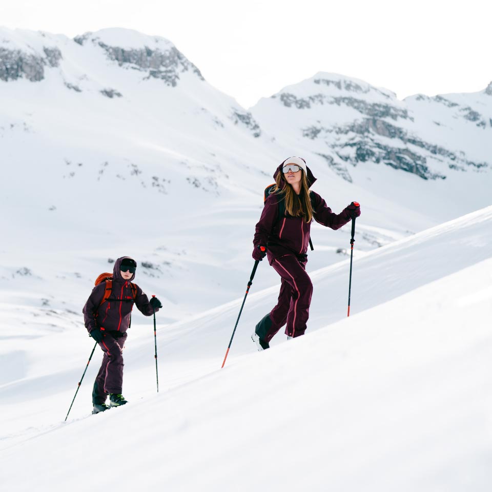 Two people ski touring in a winter landscape